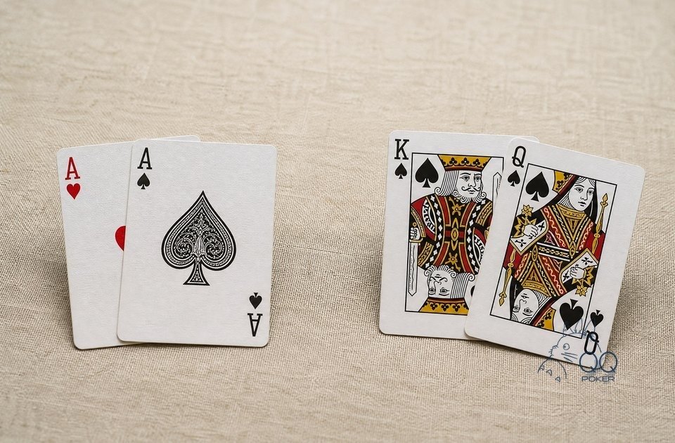 米色亚麻布上左右两组牌:左边一对 A,右边黑桃 K 与黑桃 Q